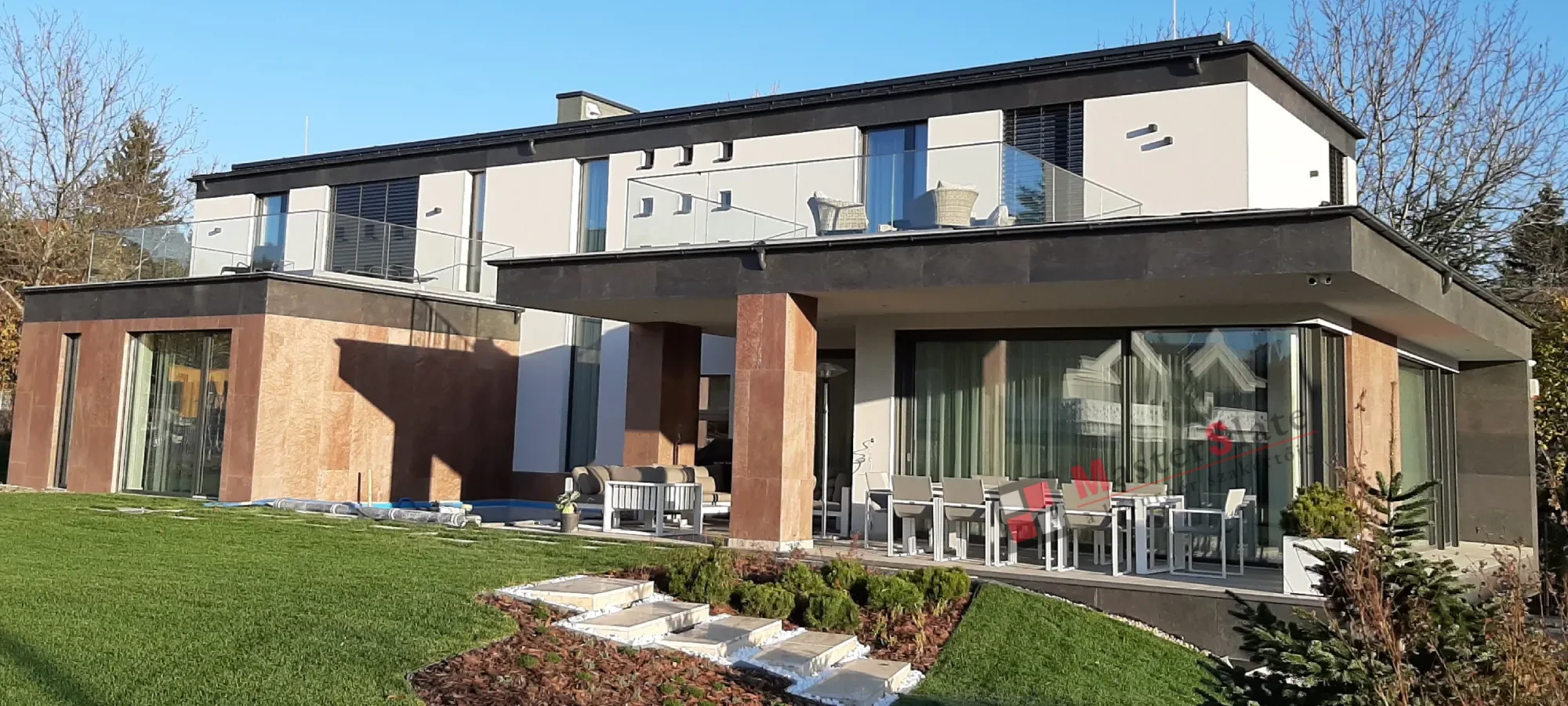 Kőfurnér burkolatú homlokzat kertes ház felől